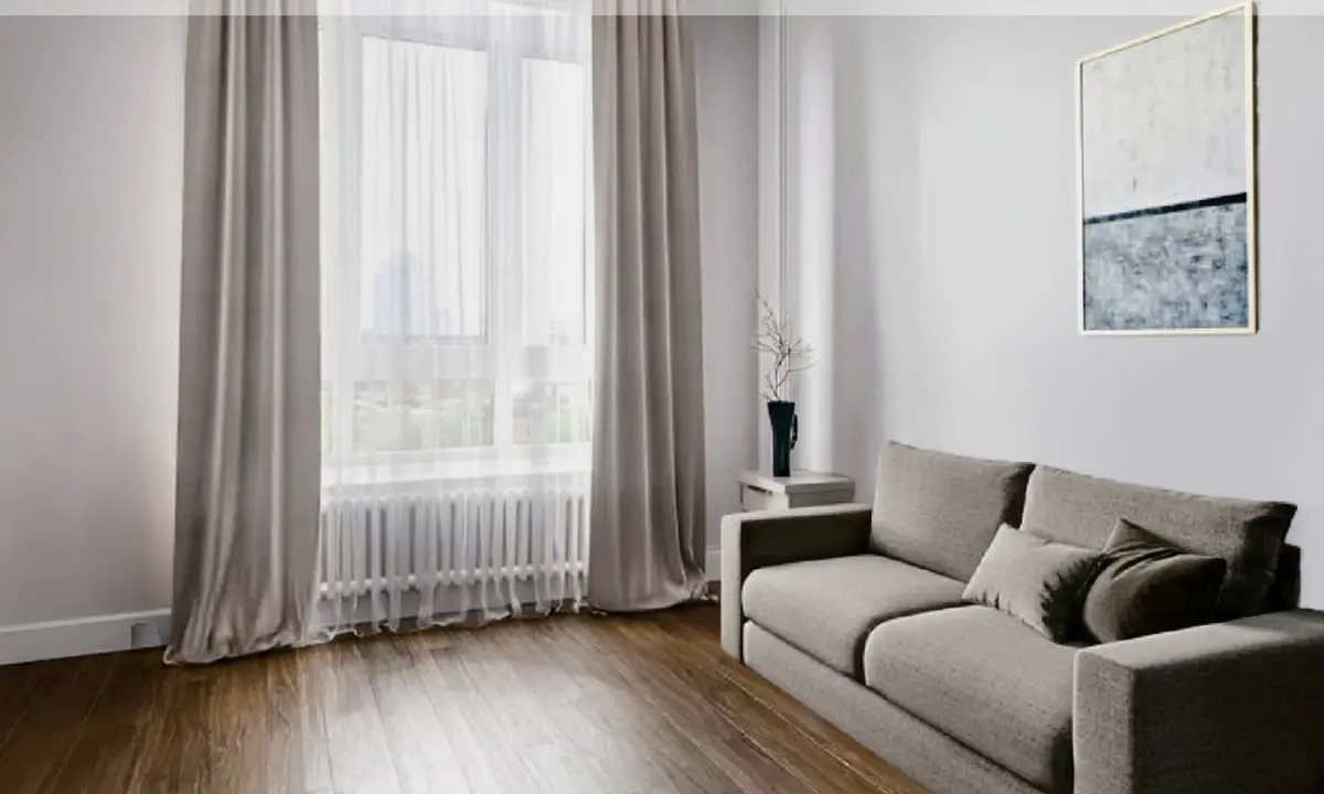 The same room furnished with a sofa, side table and framed print